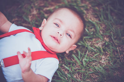 High angle portrait of baby girl lying on field