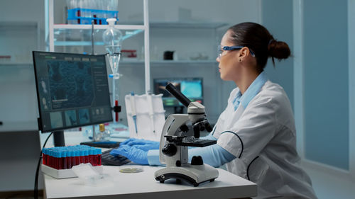 Young woman using mobile phone in laboratory