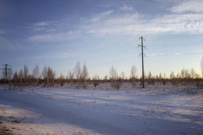 Scenic view of snow covered field against sky