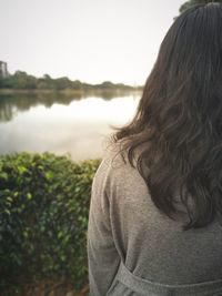 Rear view of woman in lake against sky