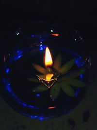 High angle view of lit candle in the dark