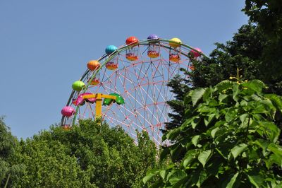 Low angle view of ferris wheel against clear blue sky