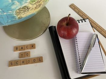 High angle view of apple and book on table