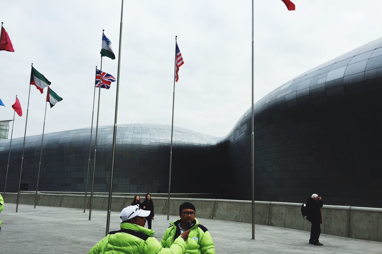 lifestyles, architecture, built structure, flag, patriotism, leisure activity, building exterior, national flag, sky, identity, men, day, casual clothing, american flag, travel, full length, standing