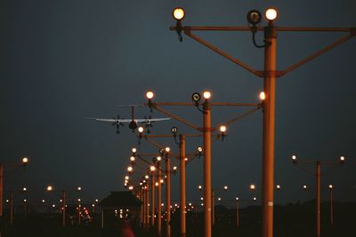 Low angle view of illuminated street lights at night