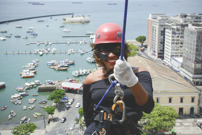 A woman dressed as a hero with a protective helmet holding the rappel rope.