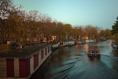 Canal in city against clear sky