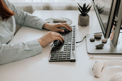 Midsection of woman using laptop on table