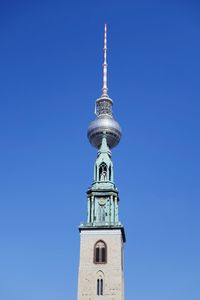 Low angle view of communications tower against clear blue sky