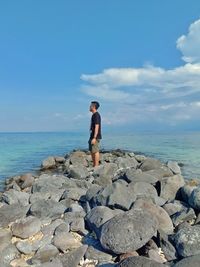 Full length of man looking at sea against sky