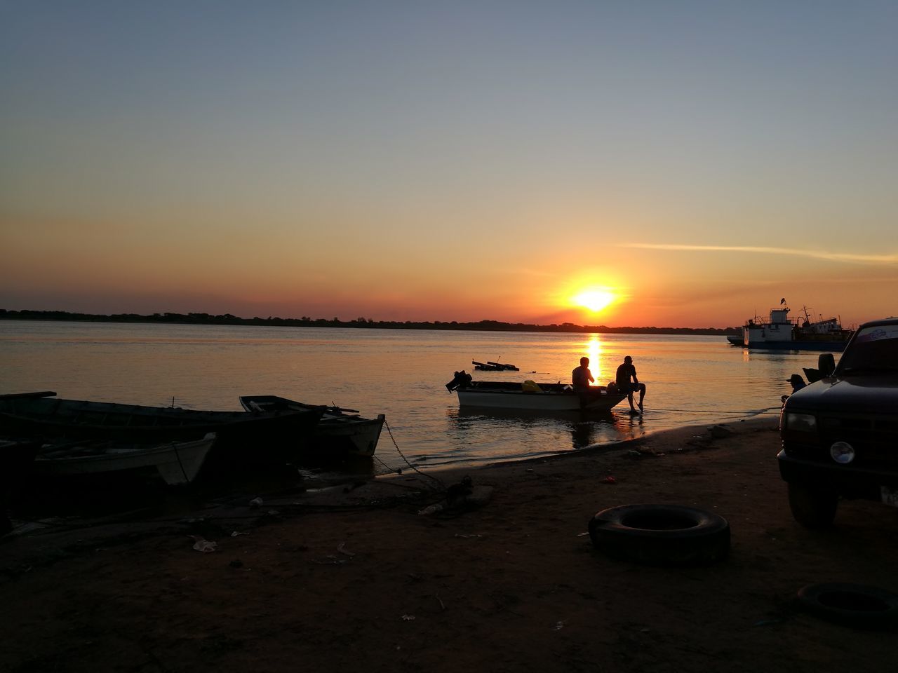 sunset, water, silhouette, nature, nautical vessel, sea, sky, beauty in nature, beach, scenics, transportation, outdoors, sun, tranquility, moored, real people, clear sky, horizon over water