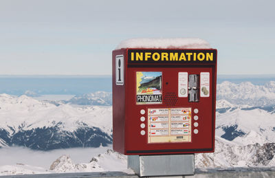 Coin-operated information equipment against snowcapped mountain