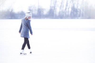 Full length of woman standing in snow covered land