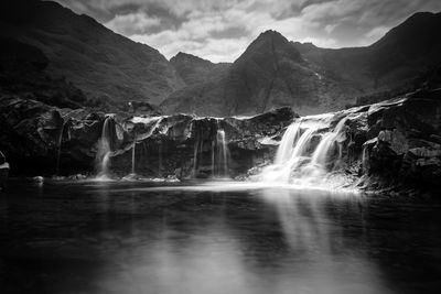 Scenic view of waterfall against sky