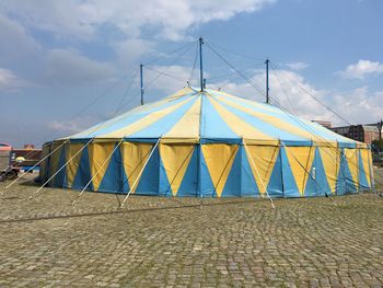 Tent on paving stones against sky