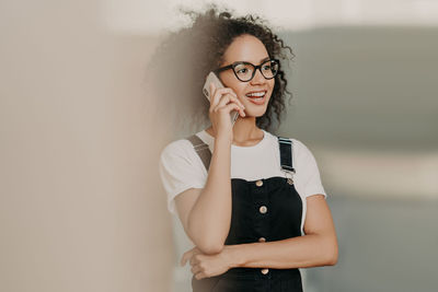 Portrait of beautiful woman standing against wall