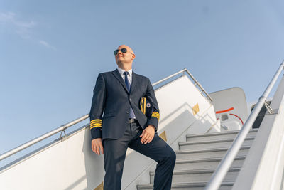 Low angle view of businessman standing against sky