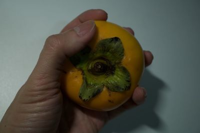 Close-up of hand holding yellow lemon