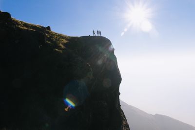 People on mountain against sky