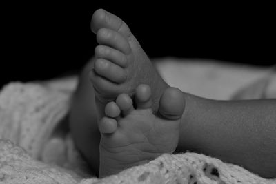 Low section of baby on bed at home