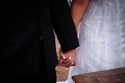 Midsection of woman holding umbrella standing at home