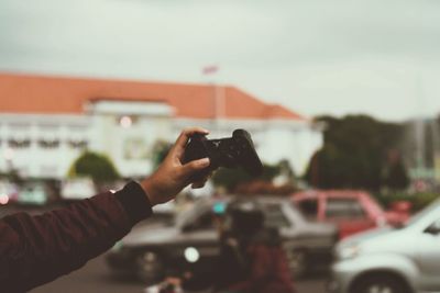 Midsection of person photographing through mobile phone