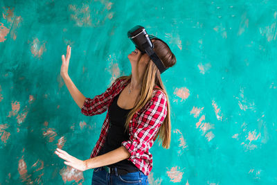 Woman standing outdoors wearing virtual reality headset