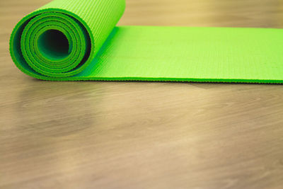 Close-up of rolled exercise mat on hardwood floor