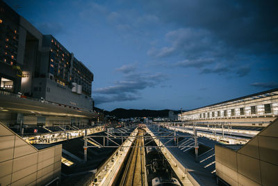 Railroad tracks amidst buildings in city against sky