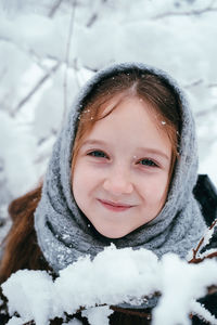 Portrait of smiling girl with snow during winter