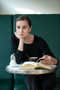 Portrait of a young woman sitting on table