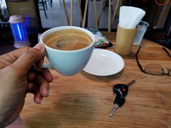 Midsection of man coffee cup on table