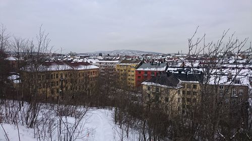 Houses in town against sky during winter