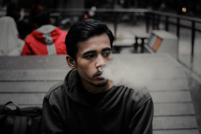 Portrait of young man sitting on seat