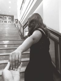 Side view of woman standing on staircase