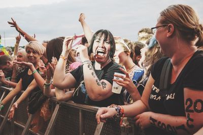 Crowd of people at music concert against sky