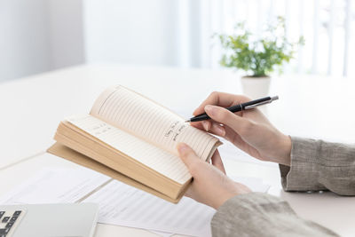 Cropped hand of woman writing in diary