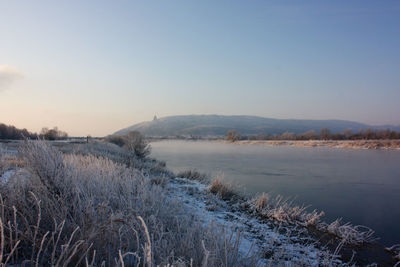 Scenic view of snow covered land against sky