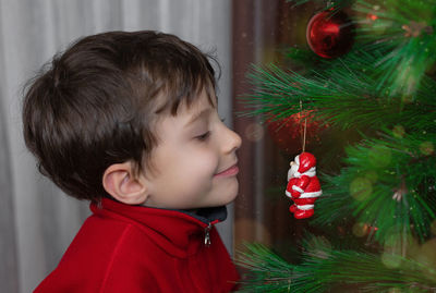 Close-up of girl playing with christmas tree at home