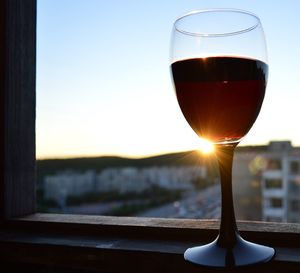 Close-up of wineglass against sunset