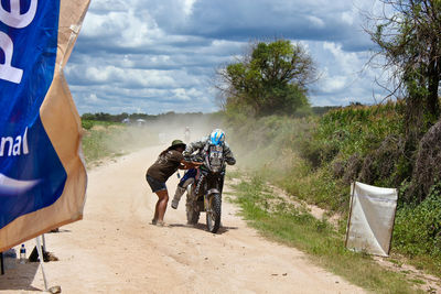 People riding motorcycle on road against sky