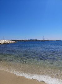 Scenic view of sea against clear blue sky