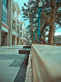 Low angle view of footpath amidst buildings in city