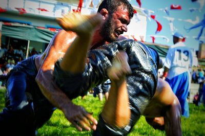 Men wrestling on field during festival