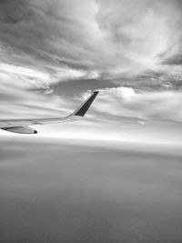 Cropped image of airplane flying over clouds