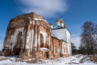 Low angle view of traditional building against sky during winter