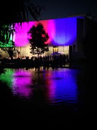 View of illuminated building with trees in background