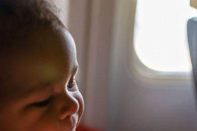 Close-up portrait of a baby by an airplane window in flight 