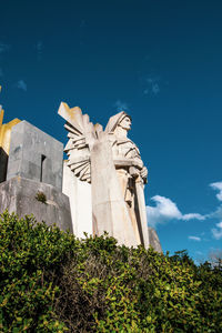 Low angle view of cross against blue sky