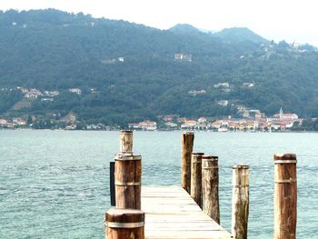 Scenic view of sea by mountain against sky